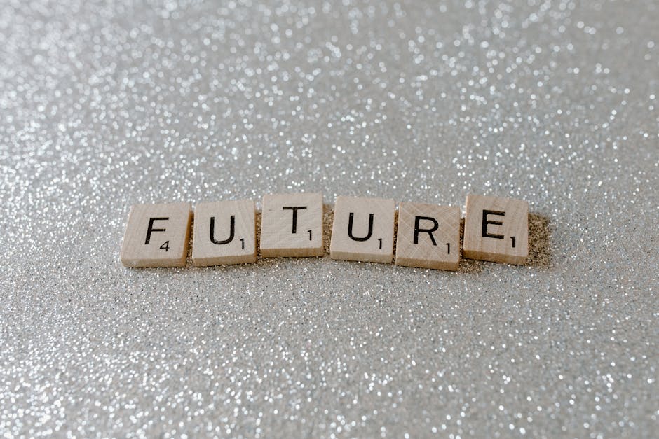 Wooden Scrabble tiles spell 'Future' against a shimmering glitter background.