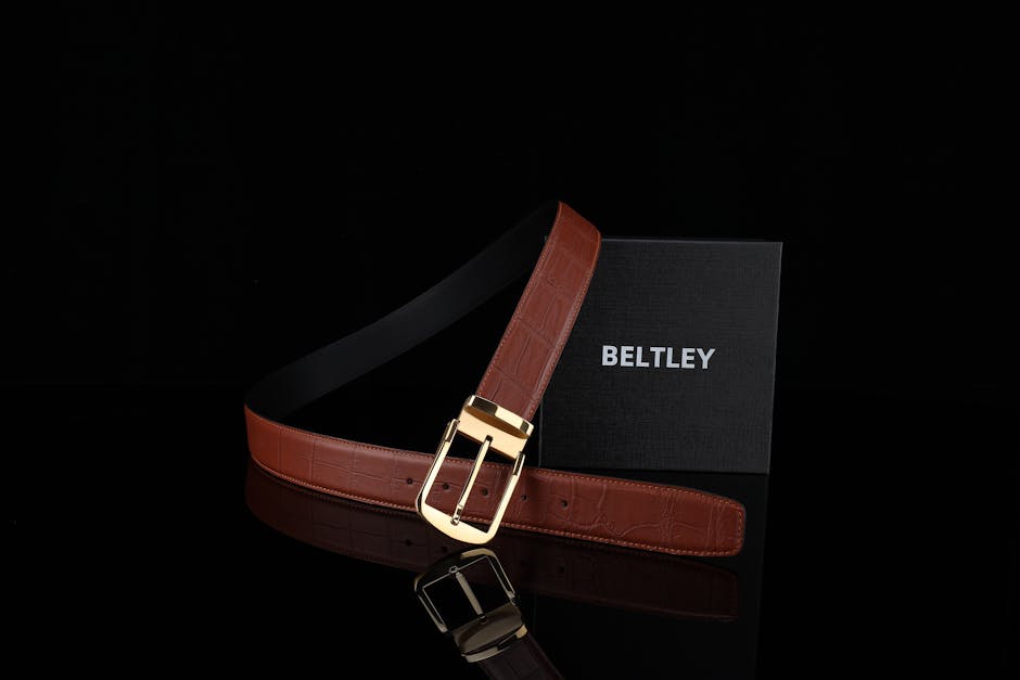 Stylish brown leather belt with a gold buckle displayed against a black background.