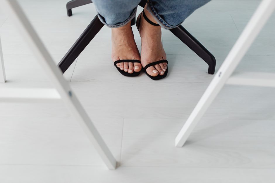 Black flat sandals worn on a summer day