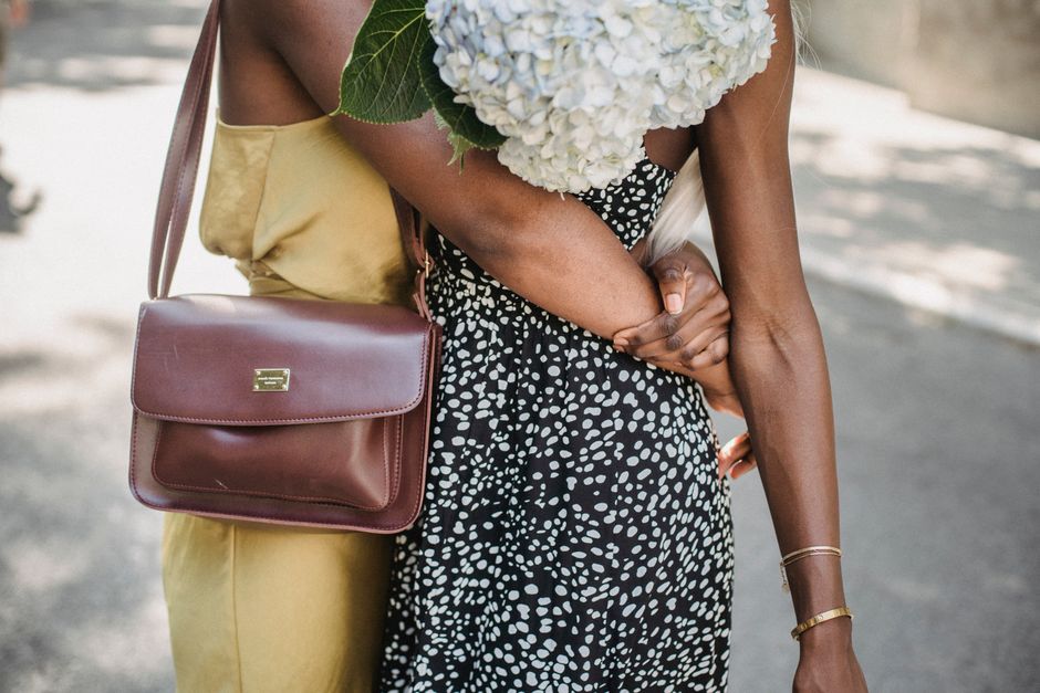 Brown leather shoulder bag worn with a summer dress
