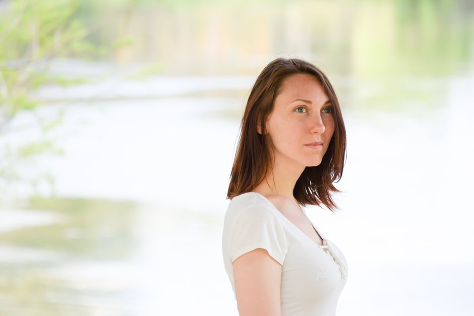 Portrait of a young woman with a natural look, outdoors in a summer setting.