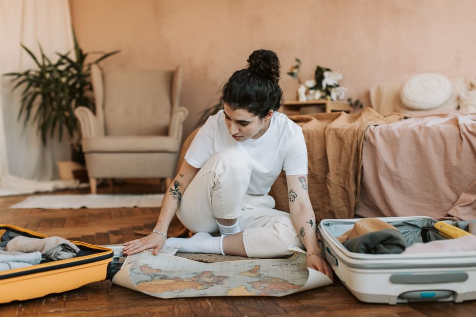 Packing folded summer clothes into an open suitcase