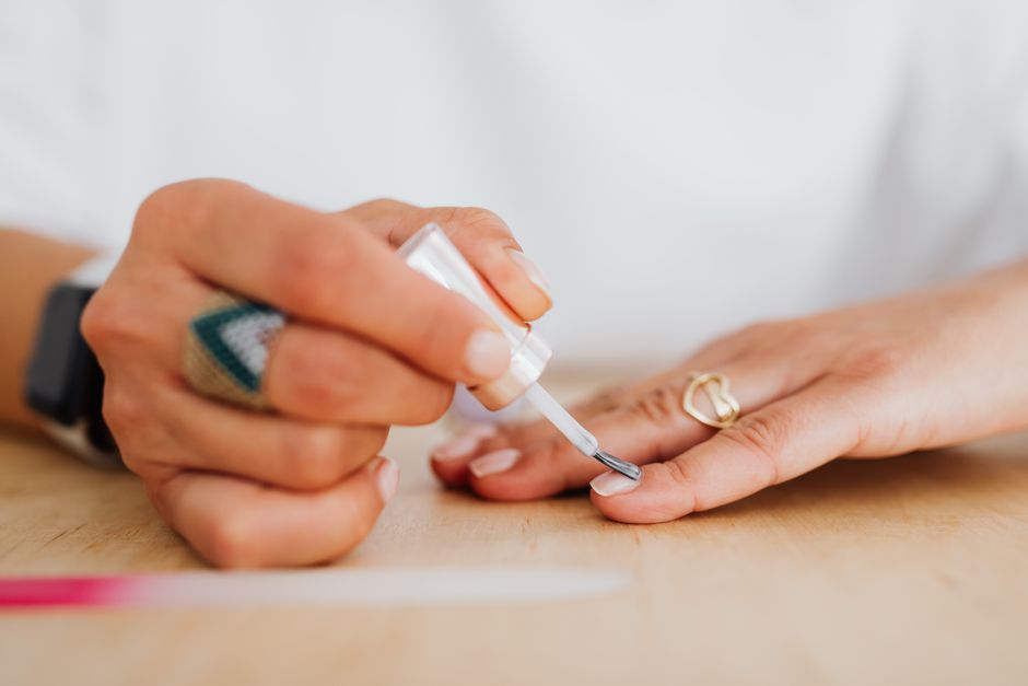 Painting fingernails with a dark winter polish shade