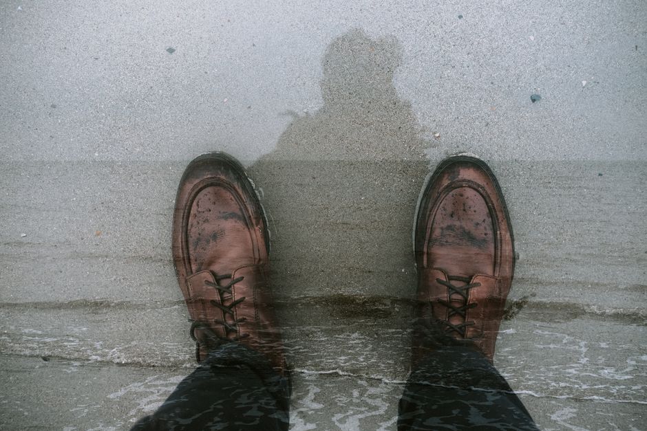 Pair of polished loafers on a wet pavement