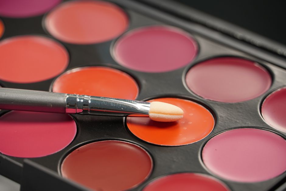 Rose and coral blush shades in a palette with a makeup brush