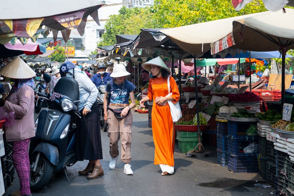 Colorful street market scene in Ho Chi Minh City with people shopping and vibrant produce stalls.