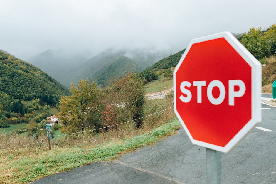 Captivating mountain landscape featuring a prominent red stop sign in the foreground.