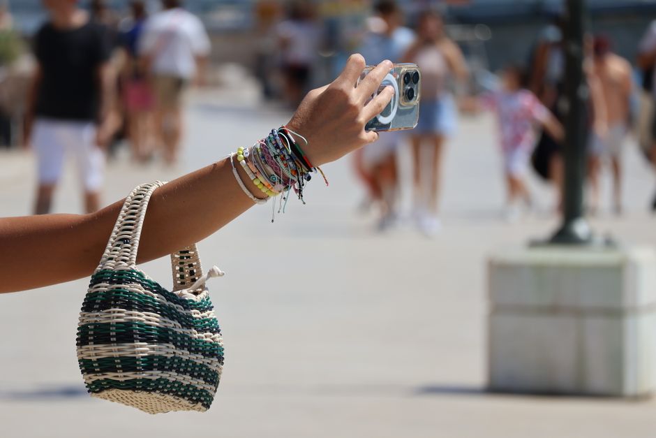 Woman carrying a small woven summer bag