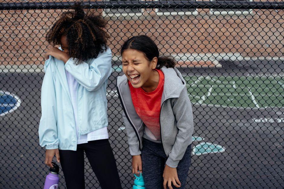 Cheerful multiracial girls in activewear having fun while resting during break in training